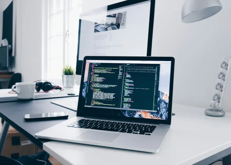 Laptop showing website code on a desk, representing WordPress maintenance